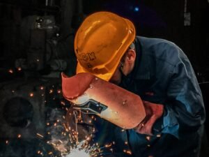 pexels photo 2480481 2480481 A welder wearing protective gear works on metal in an industrial workshop, surrounded by sparks.